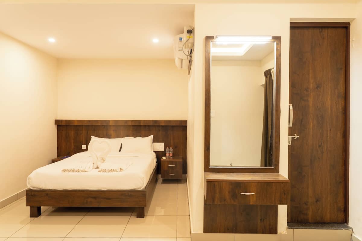 Un dormitorio con una cama de madera, una mesita de noche, un espejo y un armario.