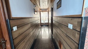 A narrow hallway with wooden paneling and a marble floor, leading to a window at the end. - RATNA VILLA INN (Darjeeling)