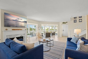A spacious living area with a fireplace, comfortable seating, and a view of the outdoors. - On the Bay - great views! Walk to Priv Beach, Pool (Siesta Key)