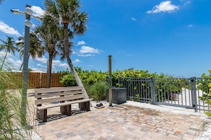 A paved patio with a wooden bench, a street lamp, and a metal gate. - On the Bay - great views! Walk to Priv Beach, Pool (Siesta Key)
