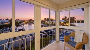 A balcony with a view of a marina and sunset. - Beautiful Condo, Waterfront, Dock Views, Walk to Private Beach, Heated Pools, Tennis, Pickleball (Siesta Key)