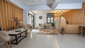 Un hall d’entrée spacieux doté d’un sol en marbre, de lambris en bois et d’un comptoir d’accueil.