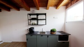A compact kitchen with a built-in shelf, a sink, and a coffee maker. - Argenteria5 Holiday Rooms (Palermo)