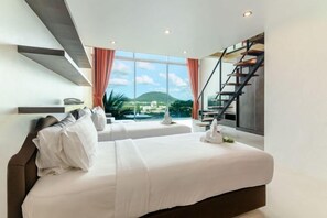 Ein modernes Hotelzimmer mit einem großen Bett, Bergblick und einer Treppe.