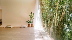 A spacious room with a large window overlooking bamboo plants. - Hilltop Wellness Living (Ratsada)