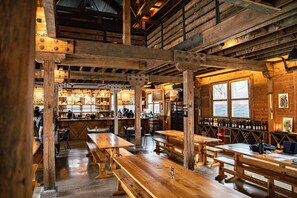 A rustic wooden interior with exposed beams, wooden tables, and benches. - Golden Holler: A Mountain Retreat in Asheville (Asheville)