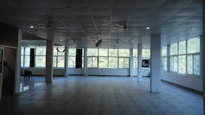 A spacious room with large windows, a high ceiling, and a wooden floor. - Vardan Hotel- Ayur Stay (Yamkeshwar)