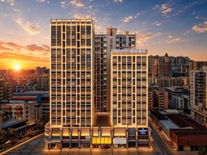 A modern hotel with a prominent 'Country' sign, featuring a grid-like facade and multiple floors. - Country Inn & Suites By Radisson (Jiangmen)