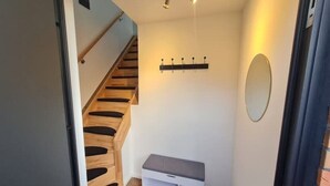 A staircase leading to a landing with a bench and a coat rack. - Dachgeschosswohnung - Erholung mit Waldblick (Mustin)