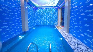 An indoor swimming pool with a ceiling displaying clouds and a blue color scheme. - Thao Nho Hotel Phu Quoc - by Bay Luxury (Phu Quoc)