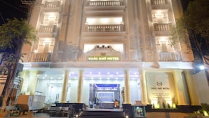 A multi-story hotel with a grand entrance, illuminated signage, and a symmetrical facade. - Thao Nho Hotel Phu Quoc - by Bay Luxury (Phu Quoc)