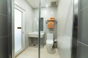 A modern bathroom with a glass shower enclosure, a sink, and a toilet. - Thao Nho Hotel Phu Quoc - by Bay Luxury (Phu Quoc)