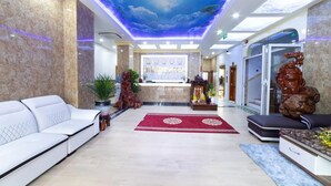 A hotel lobby with a reception desk, seating area, and a ceiling mural. - Thao Nho Hotel Phu Quoc - by Bay Luxury (Phu Quoc)