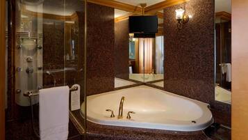 Un baño moderno con ducha de vidrio, una bañera independiente y un espejo grande que refleja el espacio.