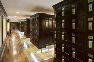 A hotel lobby with a long corridor lined with dark wooden lockers numbered 546 to 559, leading to a reception area.