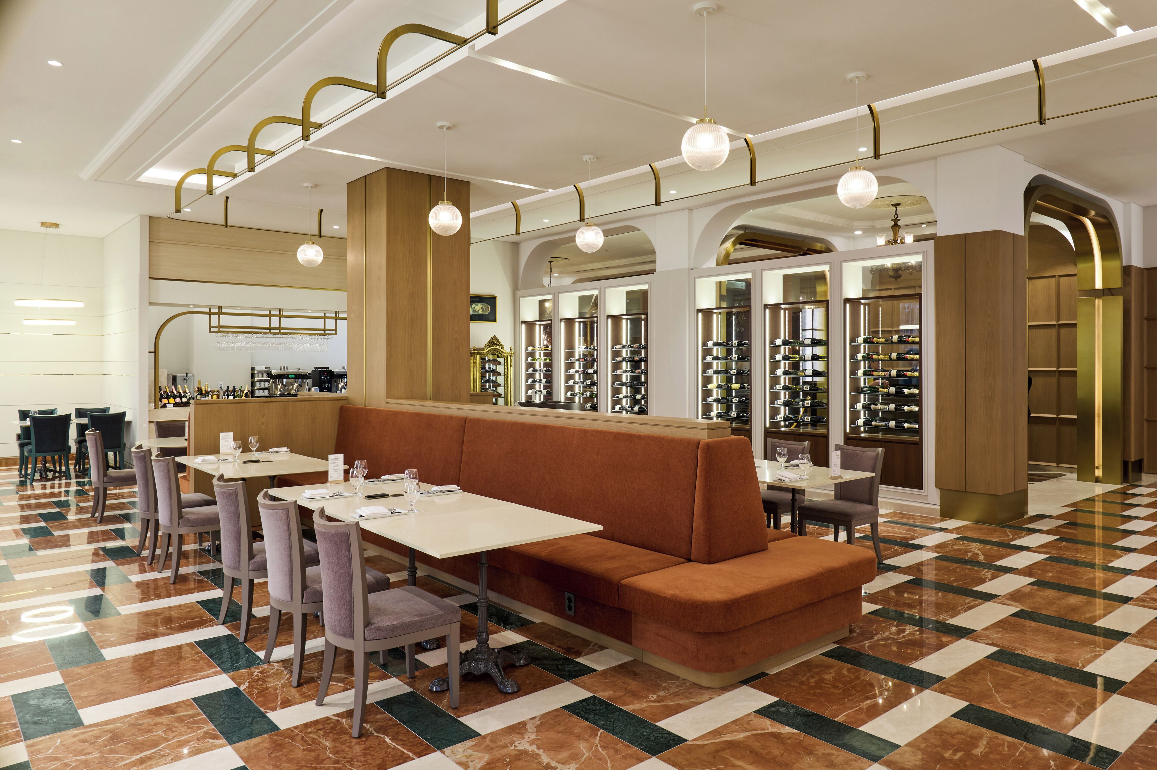 Un restaurant avec un sol à carreaux, des tables et des chaises disposées de manière harmonieuse, et un coin bar.