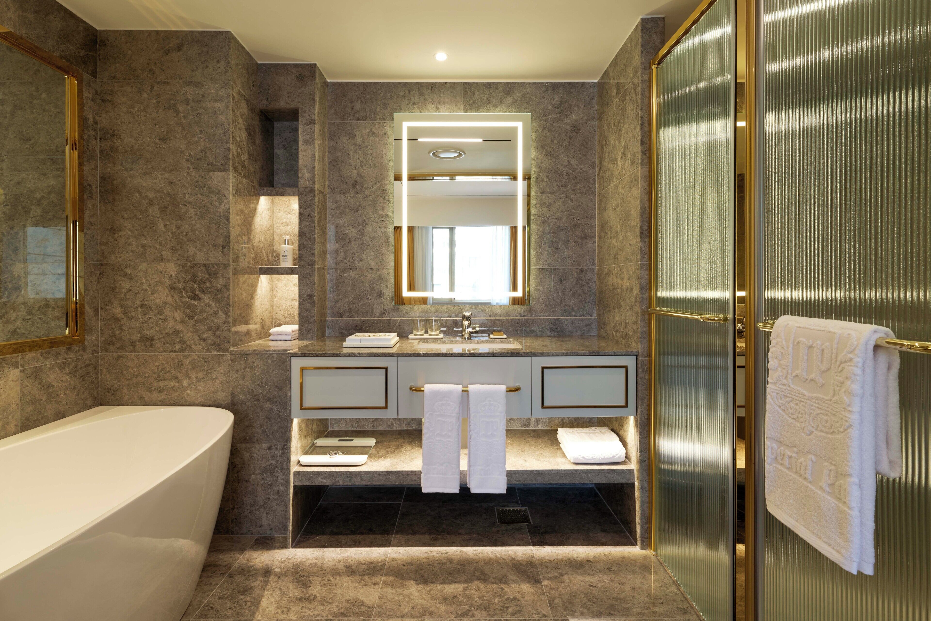 A modern bathroom with a freestanding bathtub, a large mirror, and a glass shower enclosure.