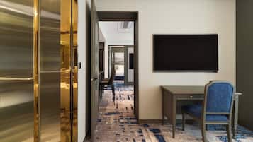 A hotel corridor with a desk and chair, a large blackboard, and a patterned carpet.
