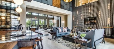 A spacious living area with a modern kitchen, a large sofa, and a dining area.