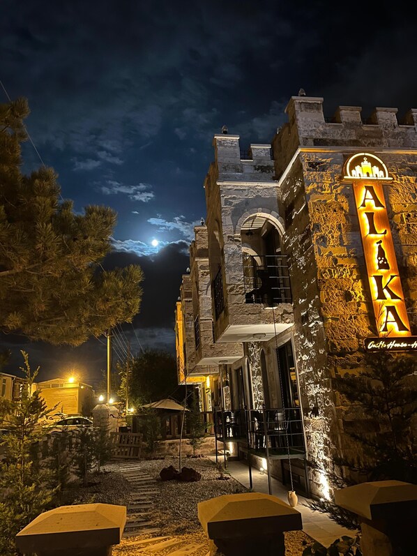 A historic building with a stone facade and a prominent illuminated sign reading "Alaka."