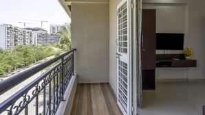 A balcony with a view of surrounding buildings and greenery. - StayBird Divine Suites Business Hotel (Pune)