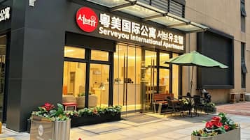 A building with a sign for 'Serveyou International Apartment'.