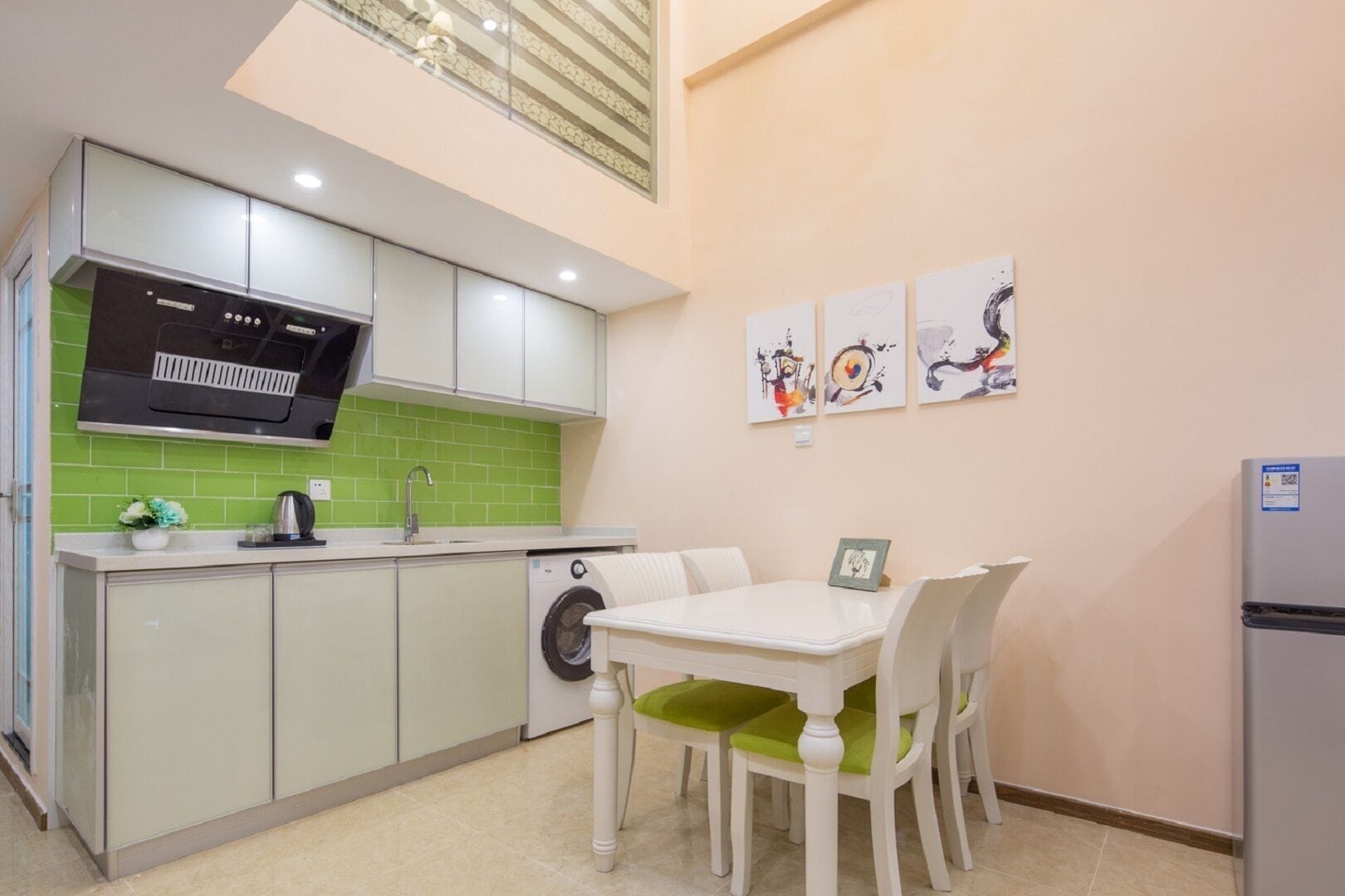 A compact kitchen with a dining area, a washing machine, and a refrigerator.
