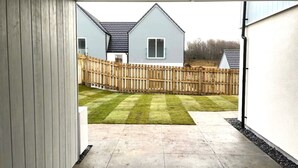 A view of a backyard with a wooden fence, a lawn, and a house in the background. - Insch House -  Retreat Group (Kingussie (nr Aviemore))