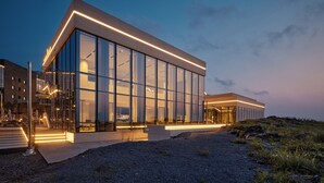 Un bâtiment moderne doté de grandes fenêtres en verre et d’un toit plat.