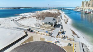 Et hotel ved stranden med en stor bygning, en mole og frit udsyn til havet.