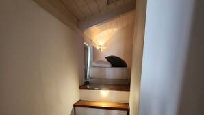 A staircase with wooden steps and a light fixture at the top. - Gaia Suites  (Turin)