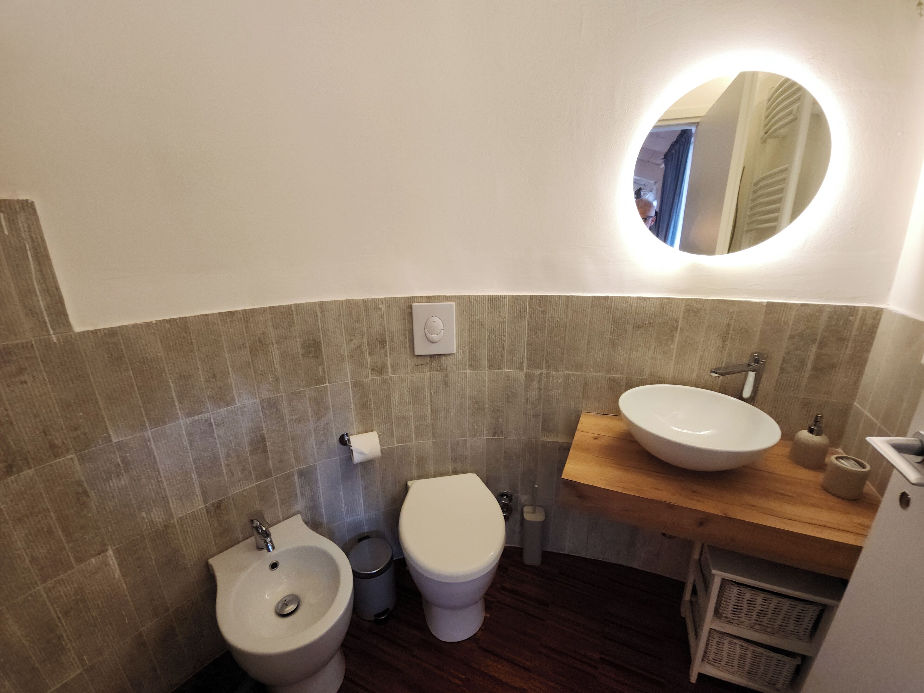 Un baño con bidé, inodoro y lavabo.