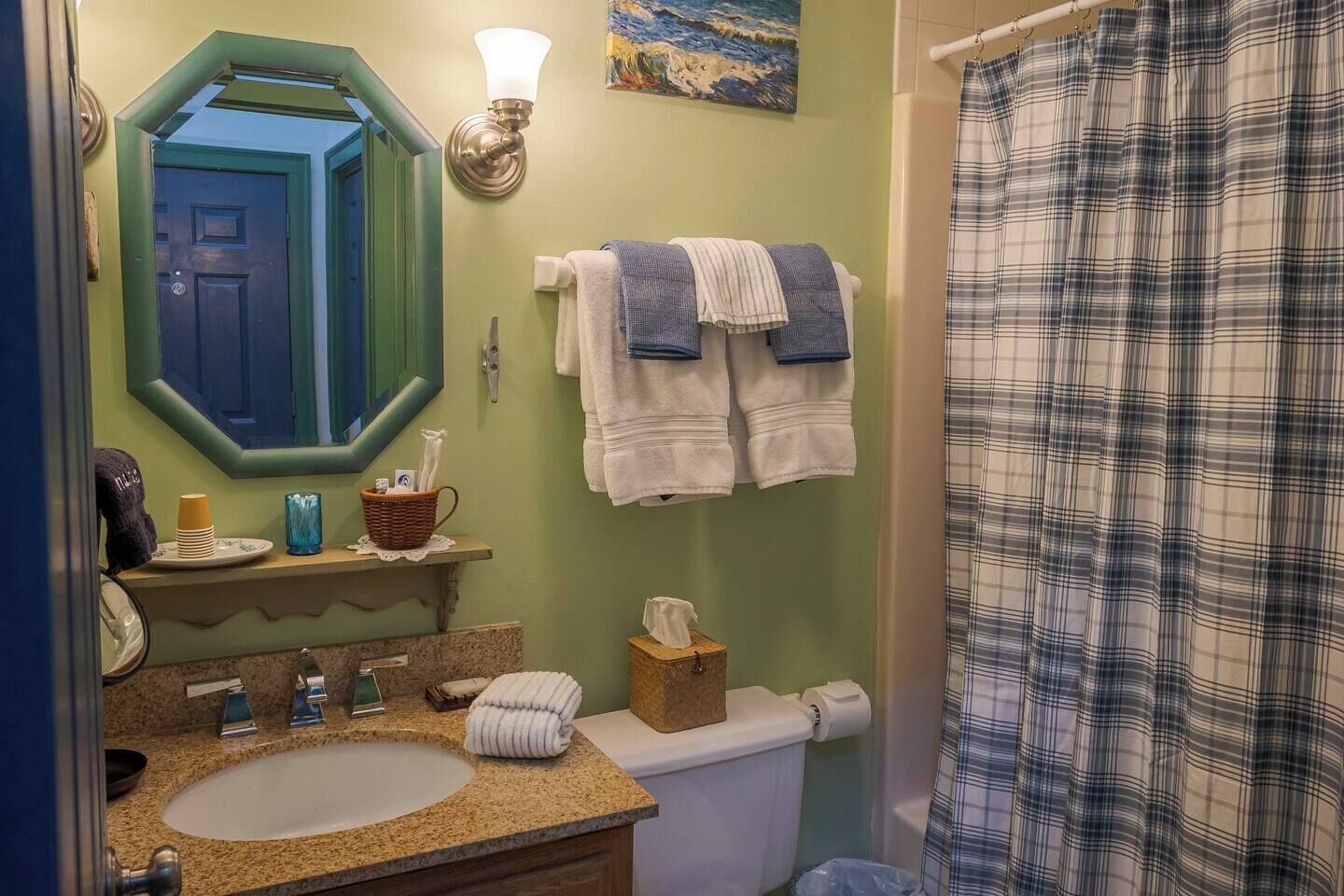 Un bagno con lavandino, specchio, porta asciugamani e tenda da doccia.