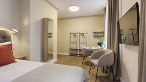 A hotel room with a bed, a desk, a chair, a wardrobe, and a mirror. - homie hotel zur stadt mainz (Würzburg)