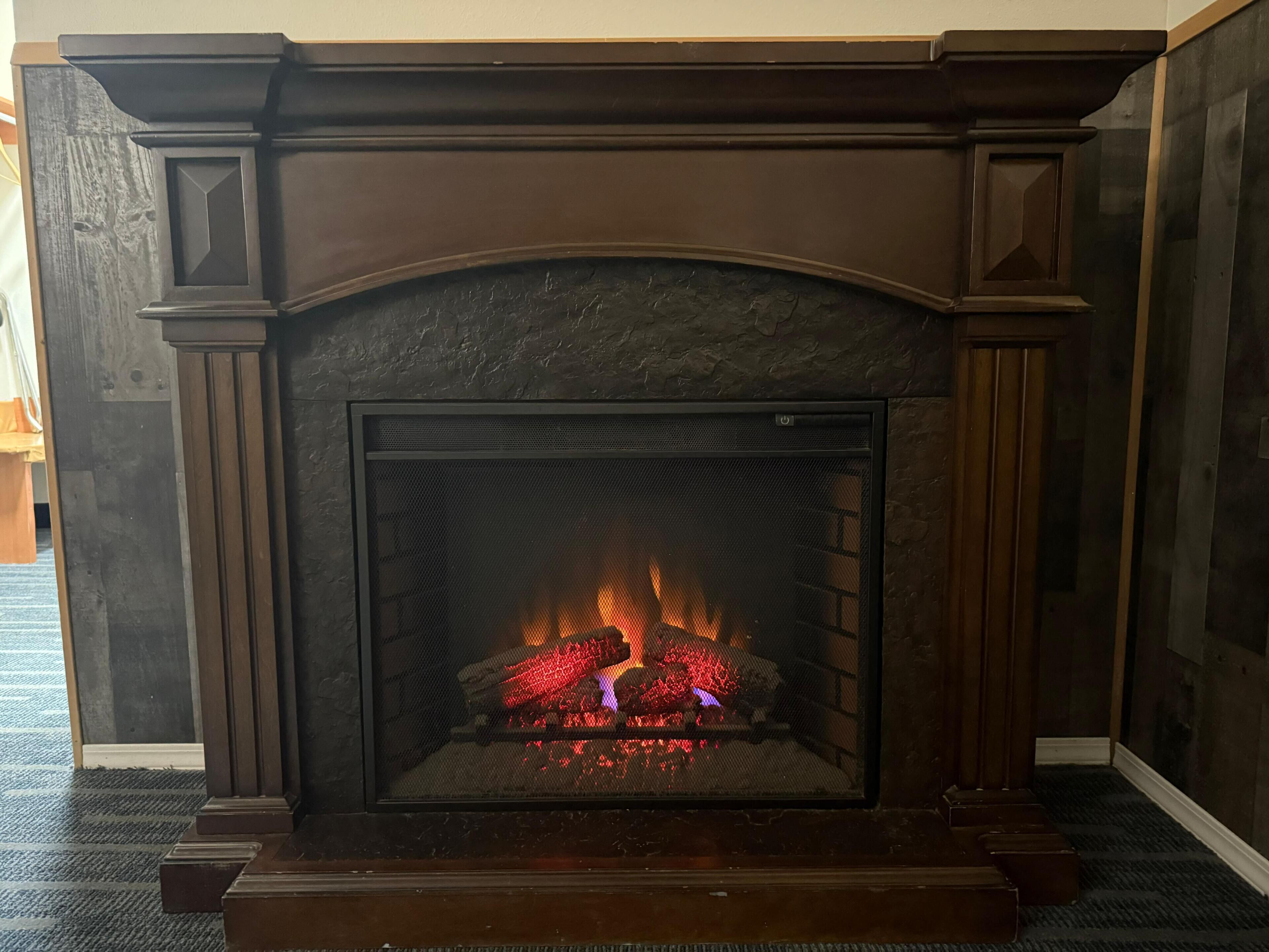Une cheminée avec un feu qui crépite à l’intérieur.