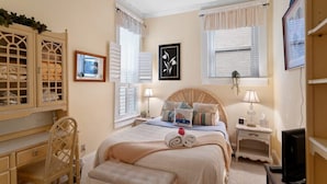 A bedroom with a bed, bedside tables, a desk, and a chair. - The Louisville Cottage | Prime Location | Near DT! (Louisville)
