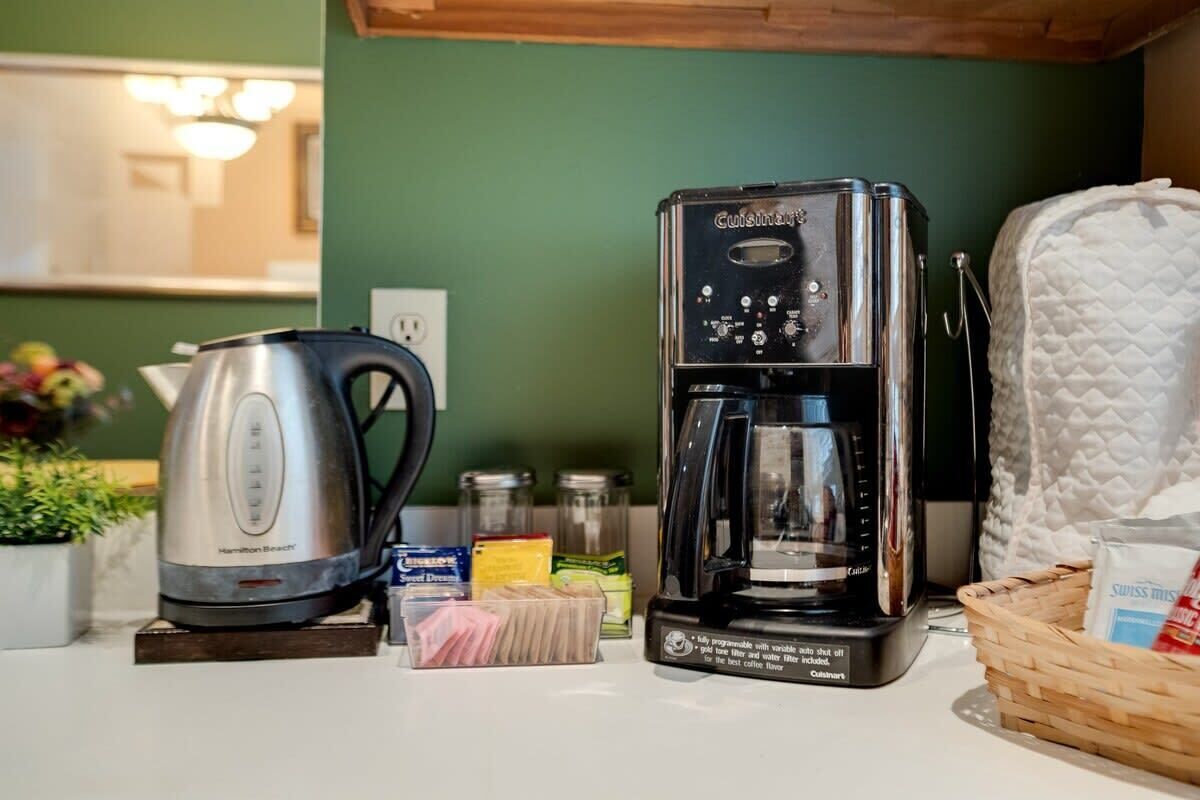 Una cocina con un hervidor Hamilton Beach, una cafetera Cuisinart y varios utensilios de cocina.