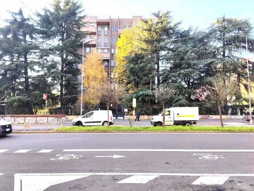 A street with a designated bike lane, a white van, and a building in the background.