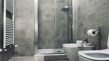 Moderni kylpyhuone, jossa on suihku, wc ja bidee.