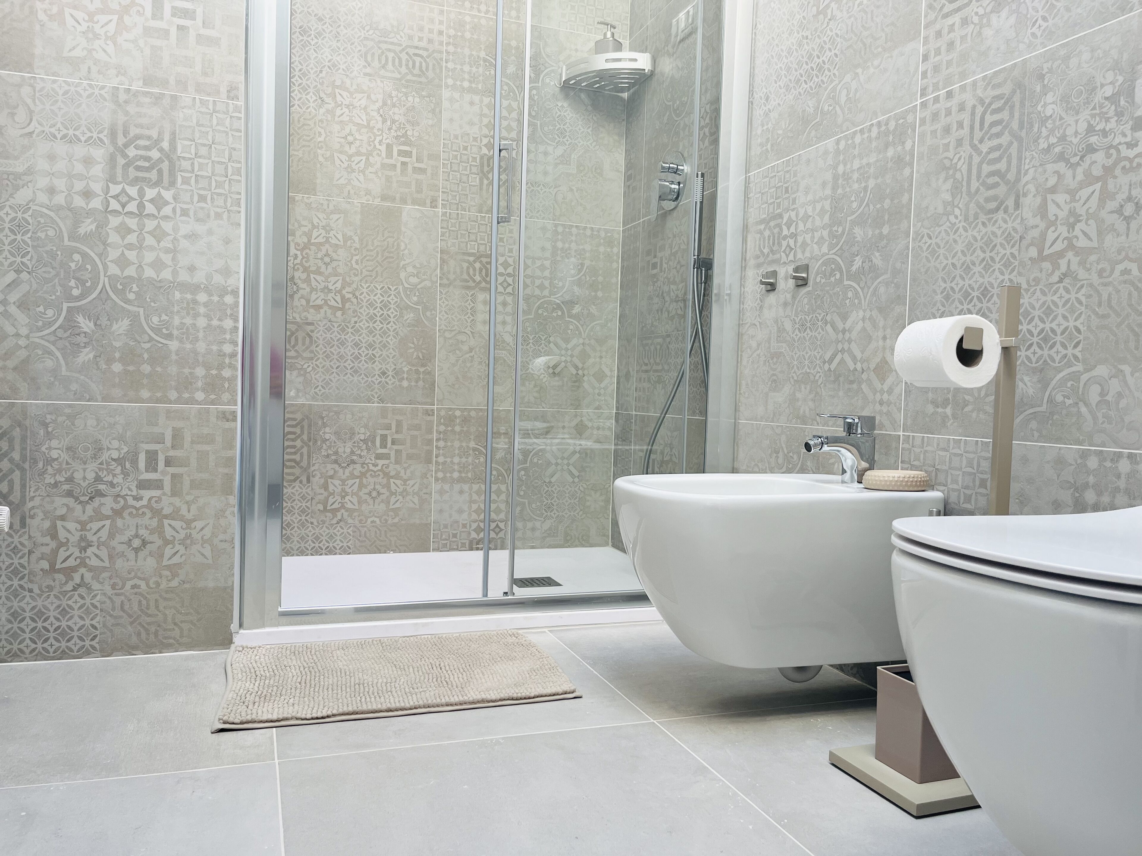 A modern bathroom with a shower, bidet, and toilet.