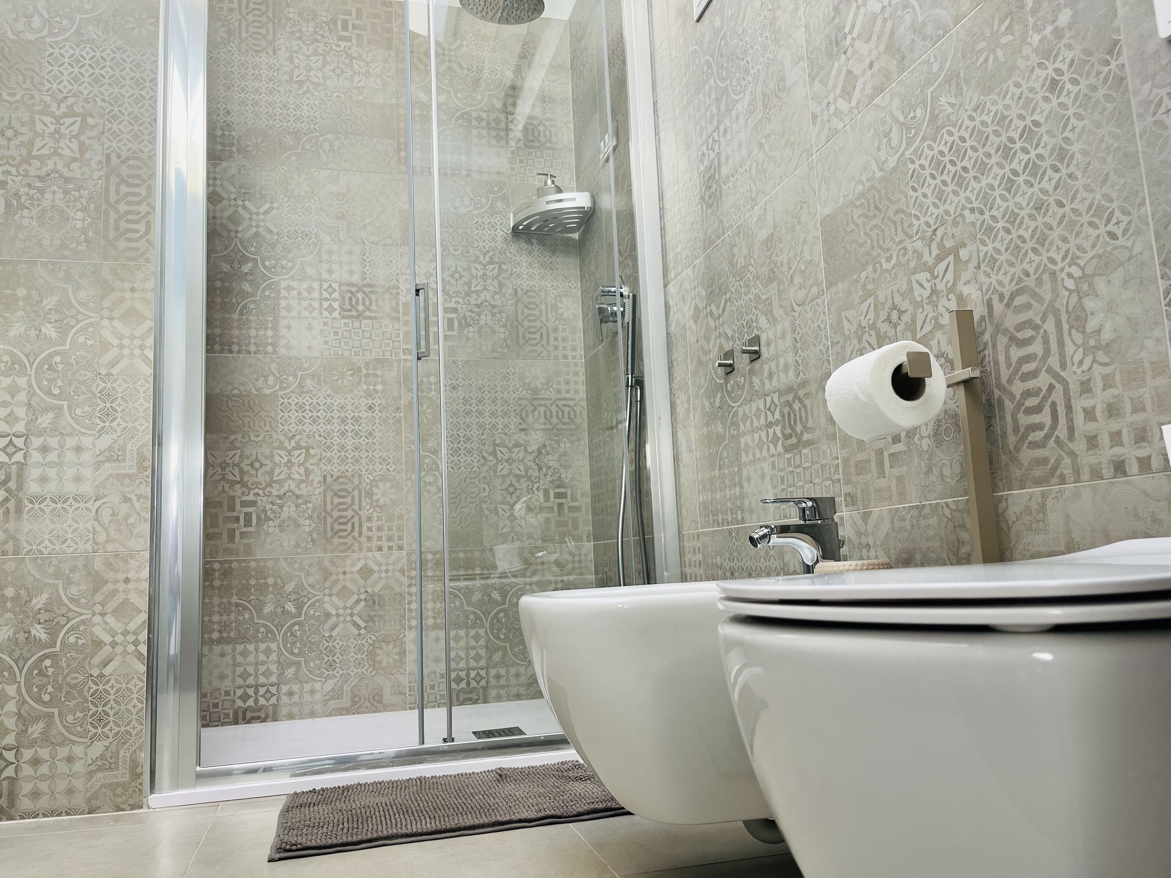 A modern bathroom with a shower, toilet, and sink.