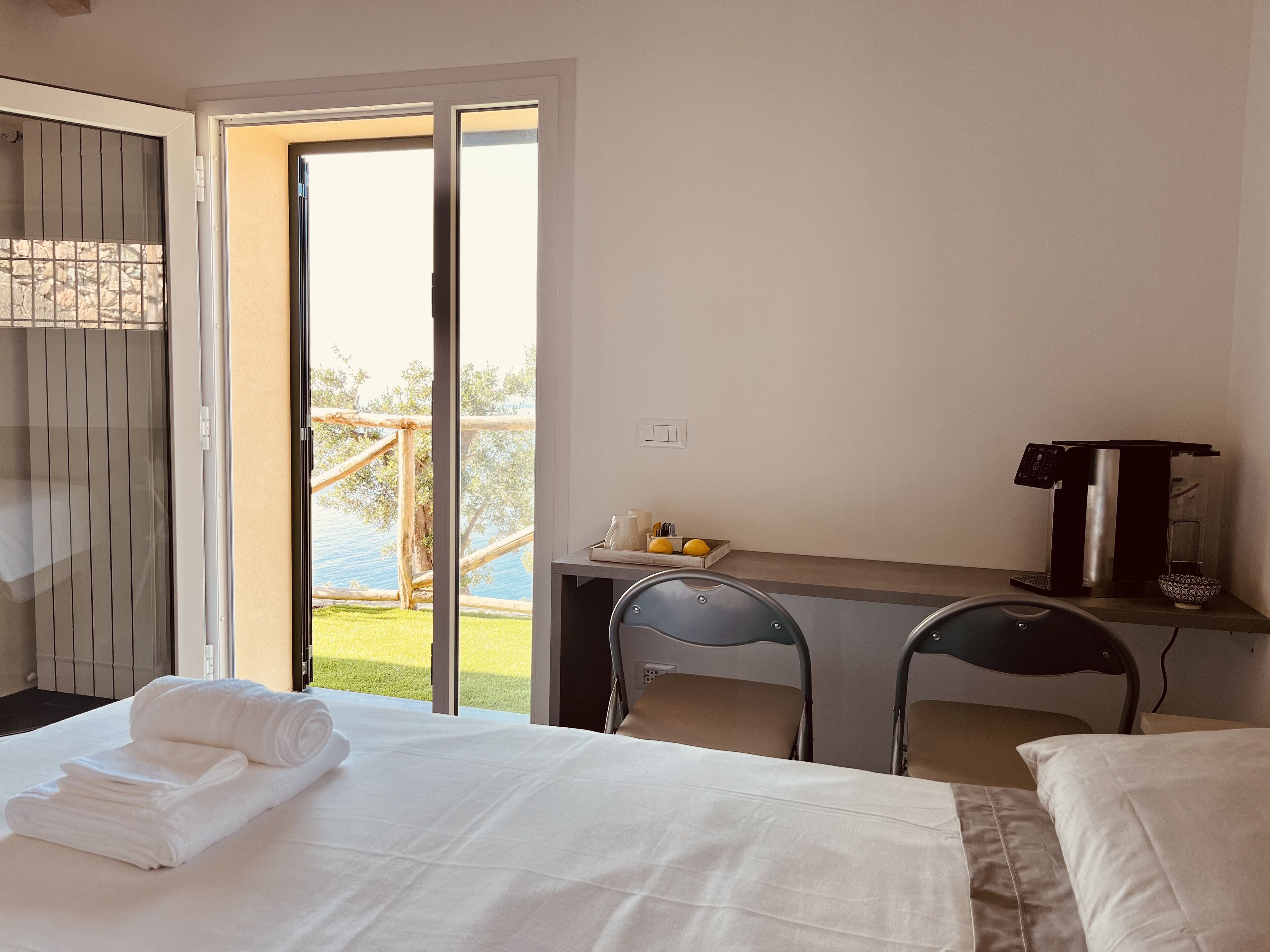 Ein Hotelzimmer mit Bett, Schreibtisch und Blick auf Pool und Bäume.