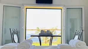 A room with a bed, two chairs, a table, and a TV. - Eufonia del Mare (Finale Ligure)