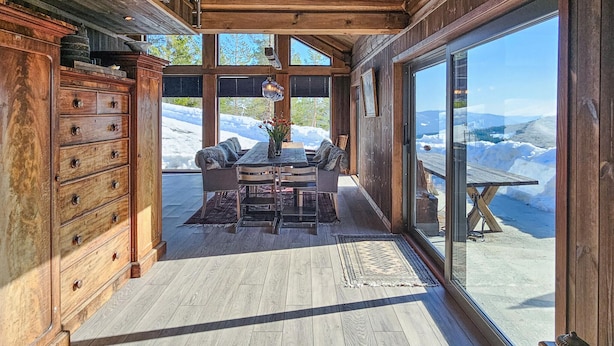 A wooden interior with a dining area, large windows, and a view of snow-covered mountains. - Gorgeous home in Passebekk with kitchen (Passebekk)