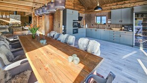 A spacious kitchen with grey cabinets, a wooden dining table, and a stone fireplace. - Gorgeous home in Passebekk with kitchen (Passebekk)