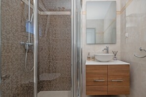 Apartamento superior, vistas al mar | Baño | Secador de pelo, toallas y papel higiénico