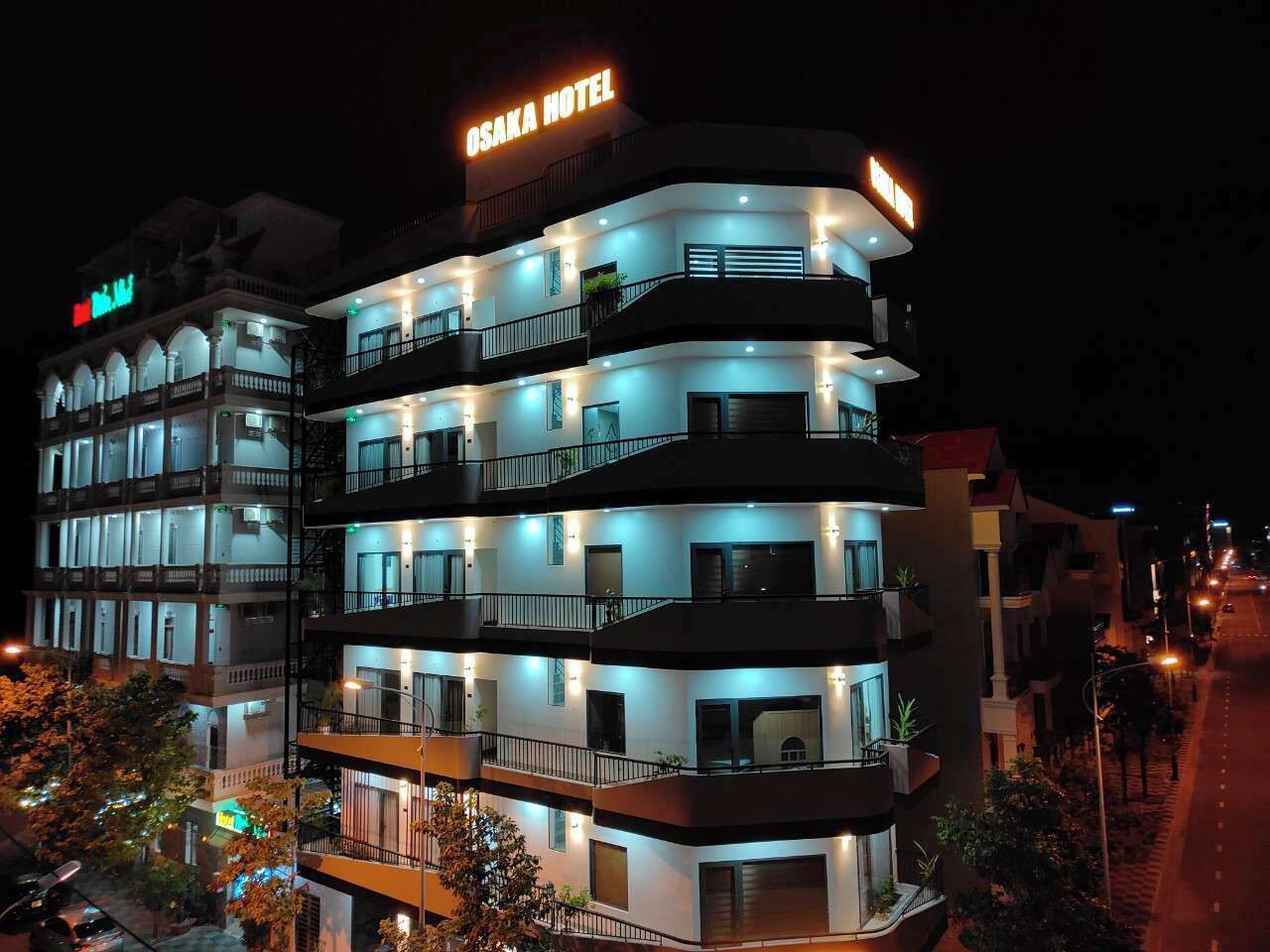 A multi-story hotel with balconies and illuminated signage.