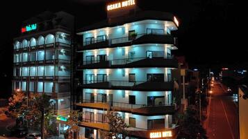 Ett hotell med flera våningar, balkonger och en skylt med texten ”OSAKA HOTEL”.