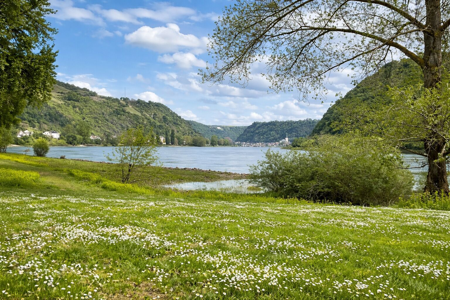 Paisagem cênica com um lago, colinas verdes e céu claro.