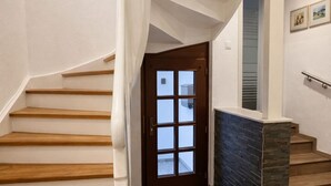 A staircase with wooden steps, a dark stone landing, and a door with glass panels. - 170 qm2 Großes, Gemütliches Haus mit Kamin und Klimaanlage. Hunde Erwünscht! (Kestert)